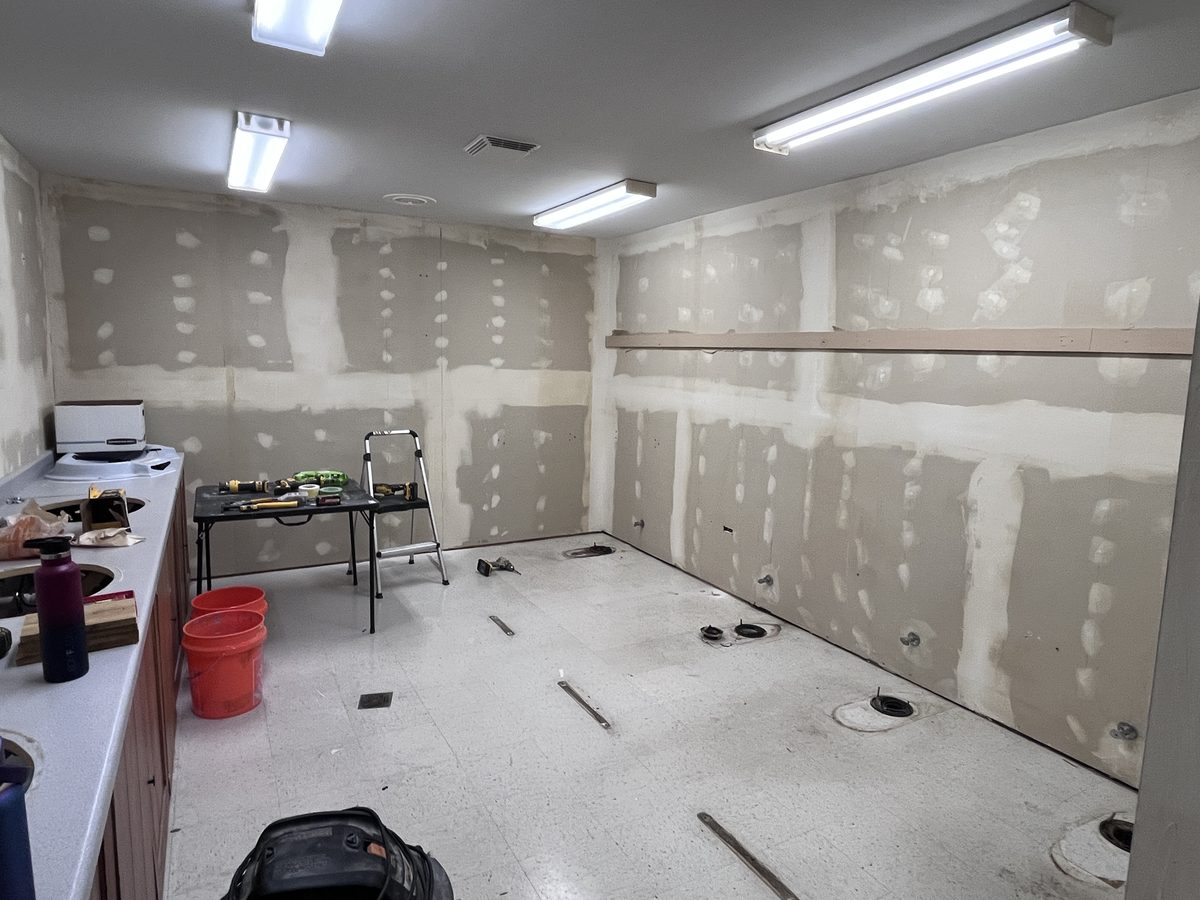 Commercial restroom in progress, with patched drywall and fixtures removed
